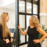 Dawn LaCarte laughing with a client standing near a doorway